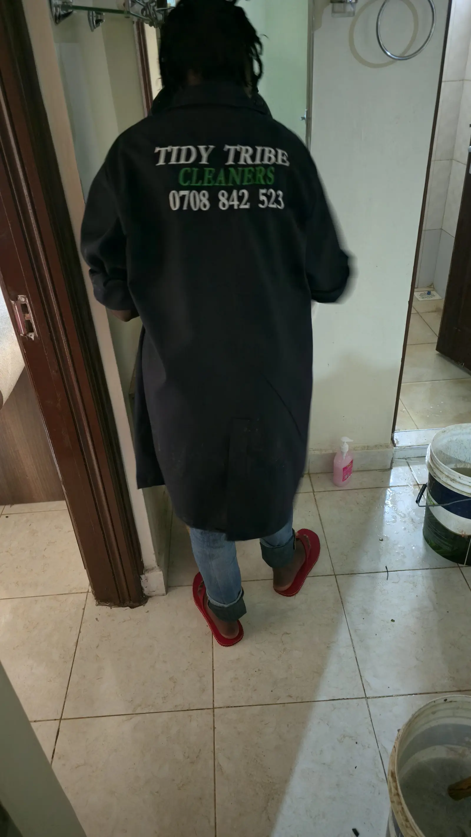 Tidy Tribe cleaner in branded overalls arriving at a customer's home